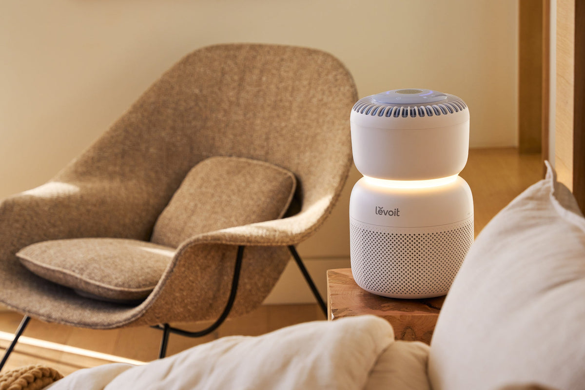 Levoit Sprout Air Purifier with nightlight on sitting on nightstand
