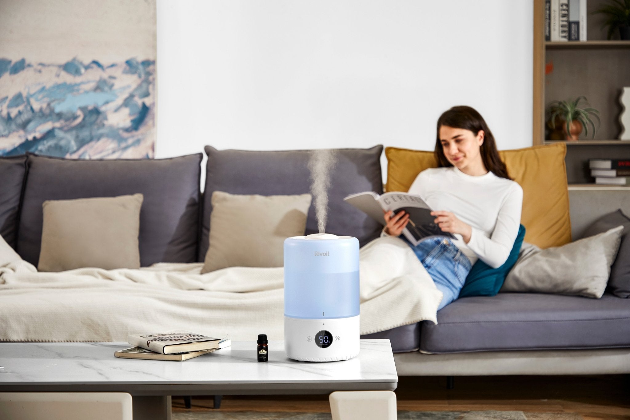 Levoit Dual 200S Blue Smart Top-Fill Humidifier diffusing essential oils in a cozy living room for relaxation.
