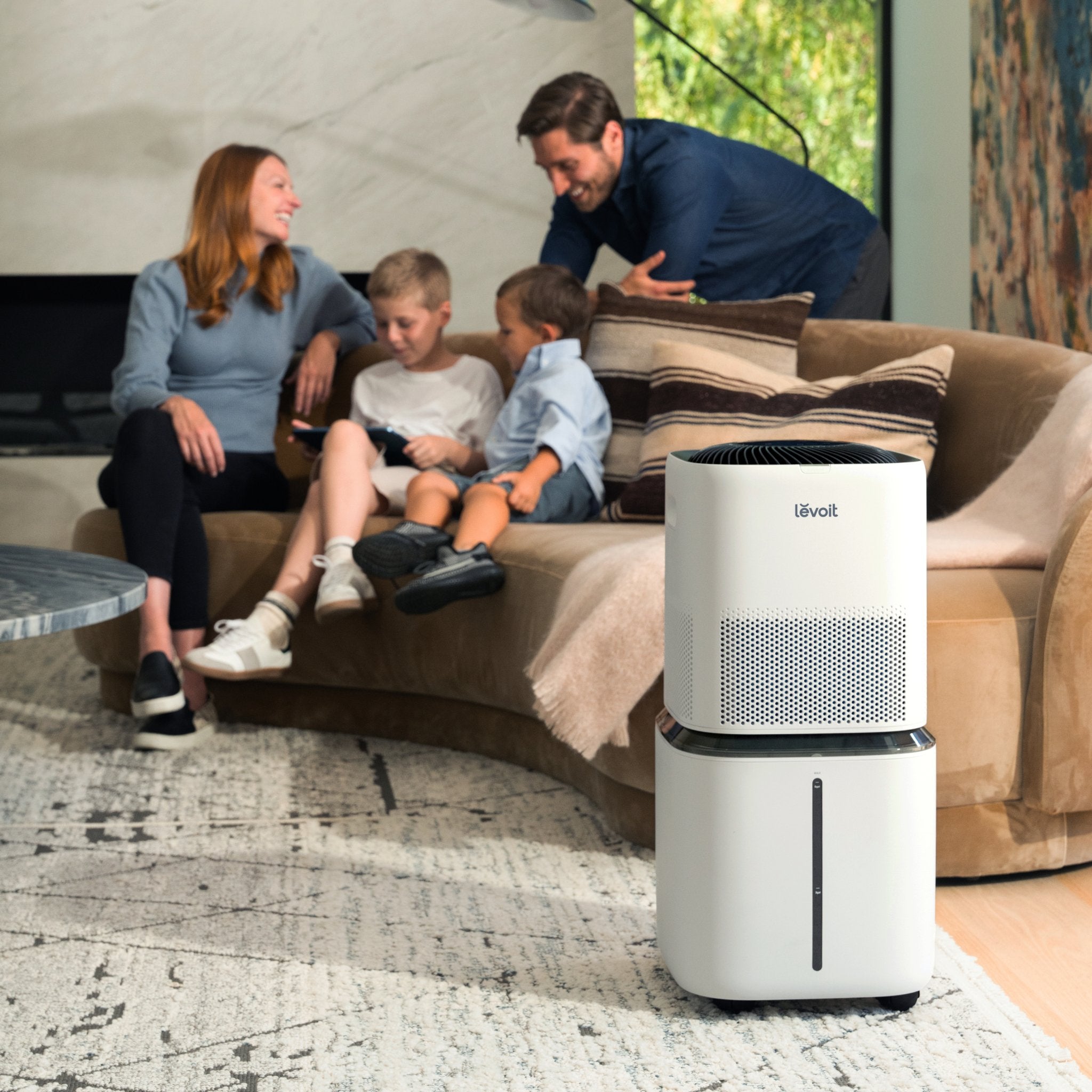 Levoit air purifier in a family living room, with a family enjoying quality time while the purifier works in the background.