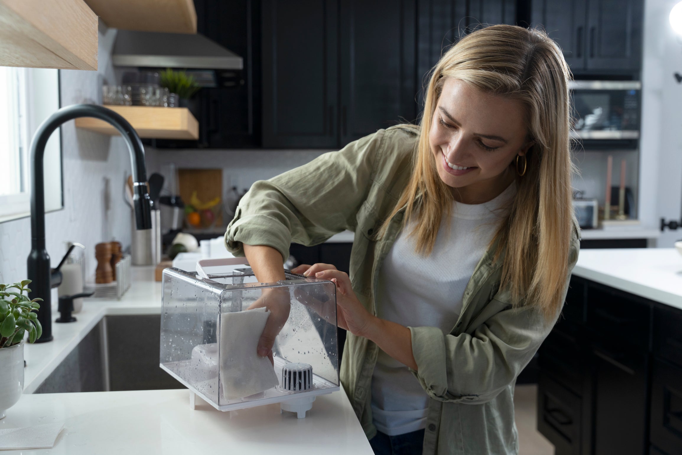 Woman wiping clean the tank of a humidifier